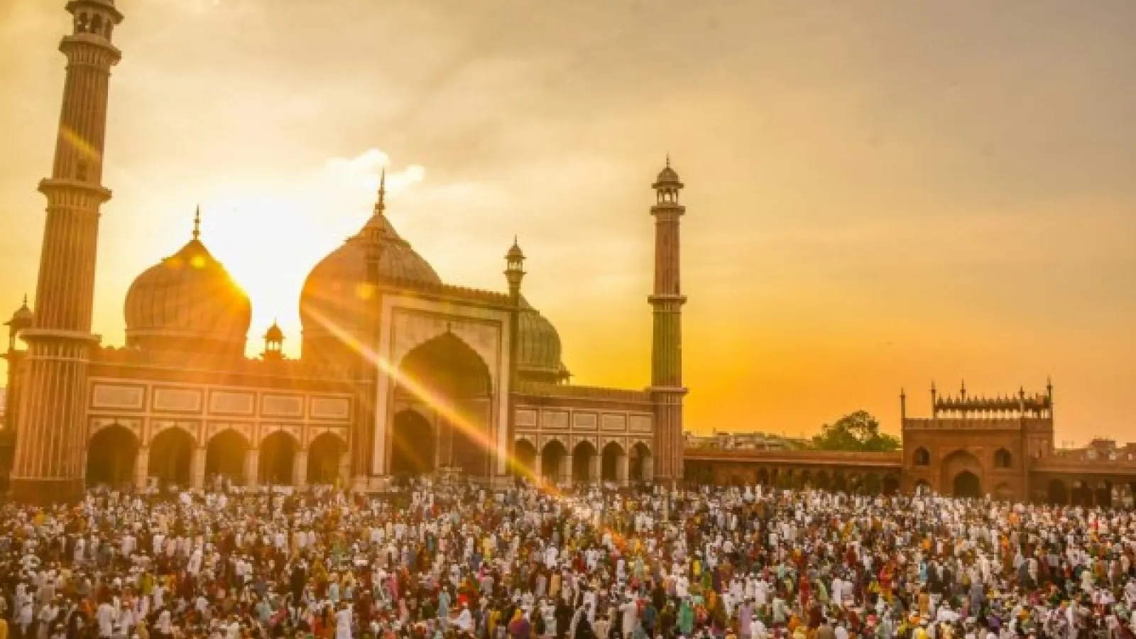 People gathering in front of a Mosque during sunrise