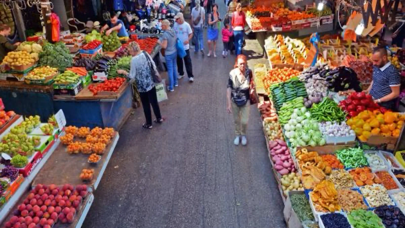 People walking through a produce market.