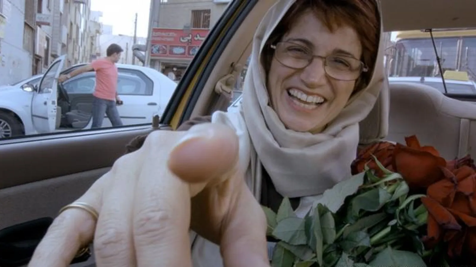 Image of a woman passanger pointing at the driver - from the driver's point of view
