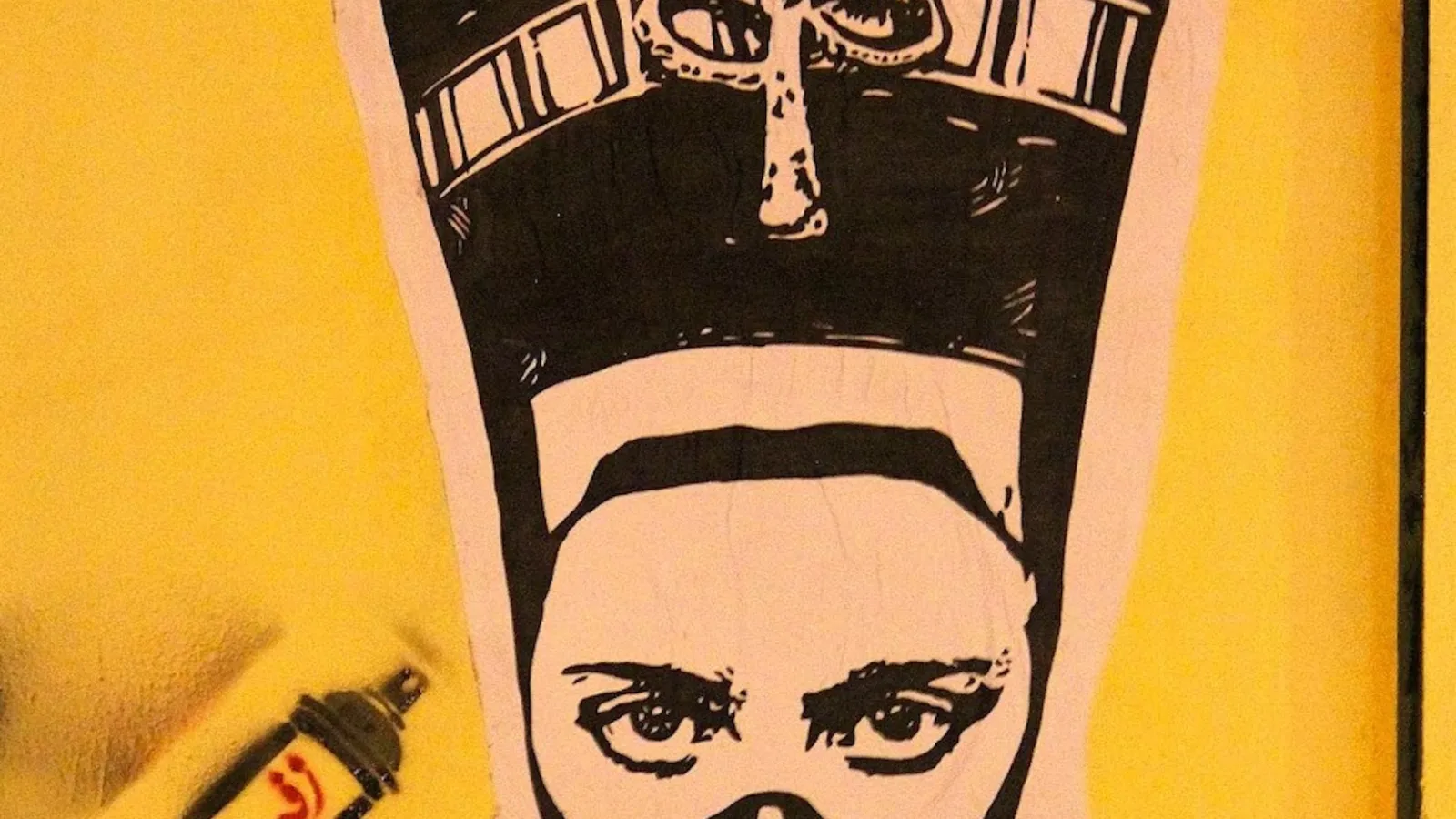Image still from the film: a stenciled image of Nefertiti with a gas mask