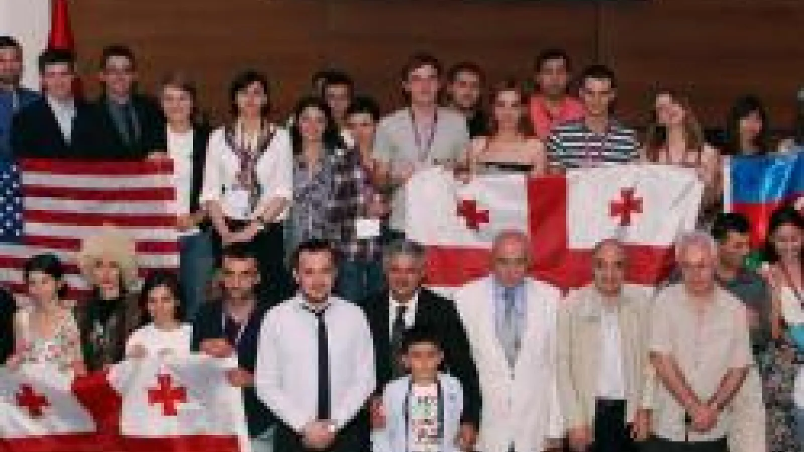 A group of people holding an American flag and two flags from Georgia