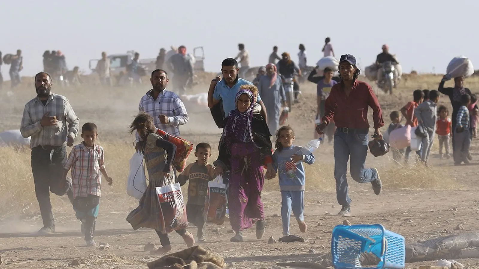 a scene from Arab Spring of families running in a desert 
