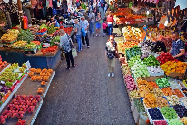 People walking through a produce market.