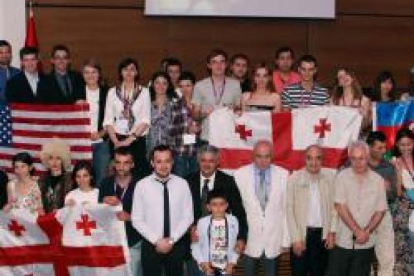 A group of people holding an American flag and two flags from Georgia